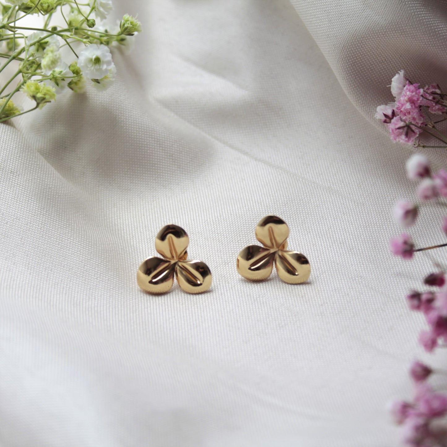 Fabricados en acero inoxidable hipoalergénico de alta calidad, los pendientes Cleo destacan por su delicado diseño floral en tono dorado.